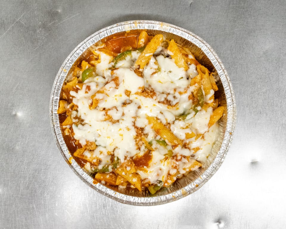 Baked penne pasta with melted mozzarella cheese, tomato sauce, and green peppers in a foil container.