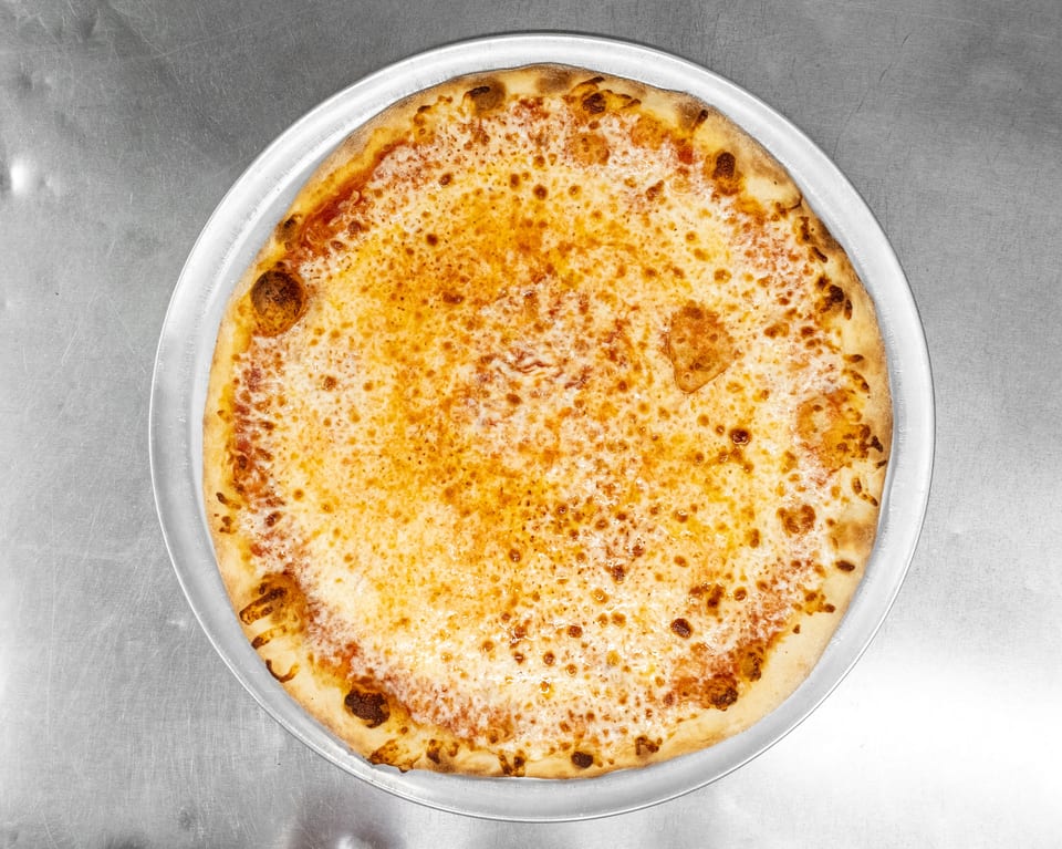 A freshly baked cheese pizza with a golden crust on a metal pan, viewed from above.