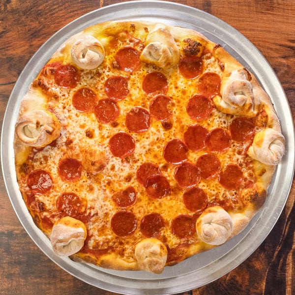 A pepperoni pizza with garlic knots baked into the crust, on a metal tray.